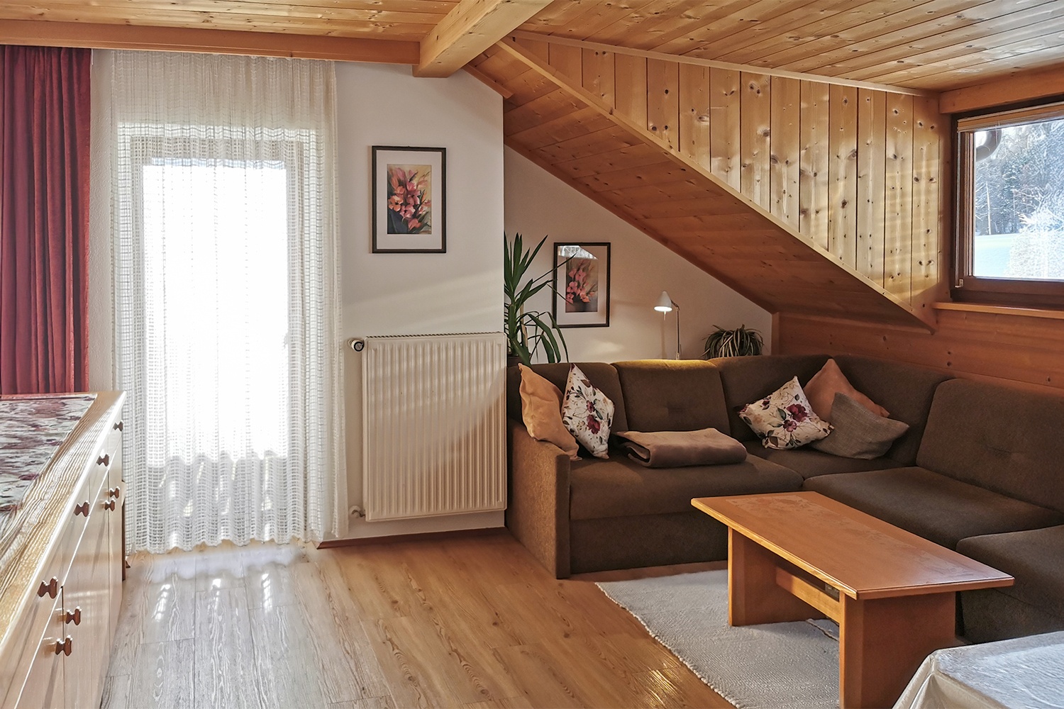 Helles Wohnzimmer mit gemütlicher Couch und großem Tisch für bis zu 10 Personen.