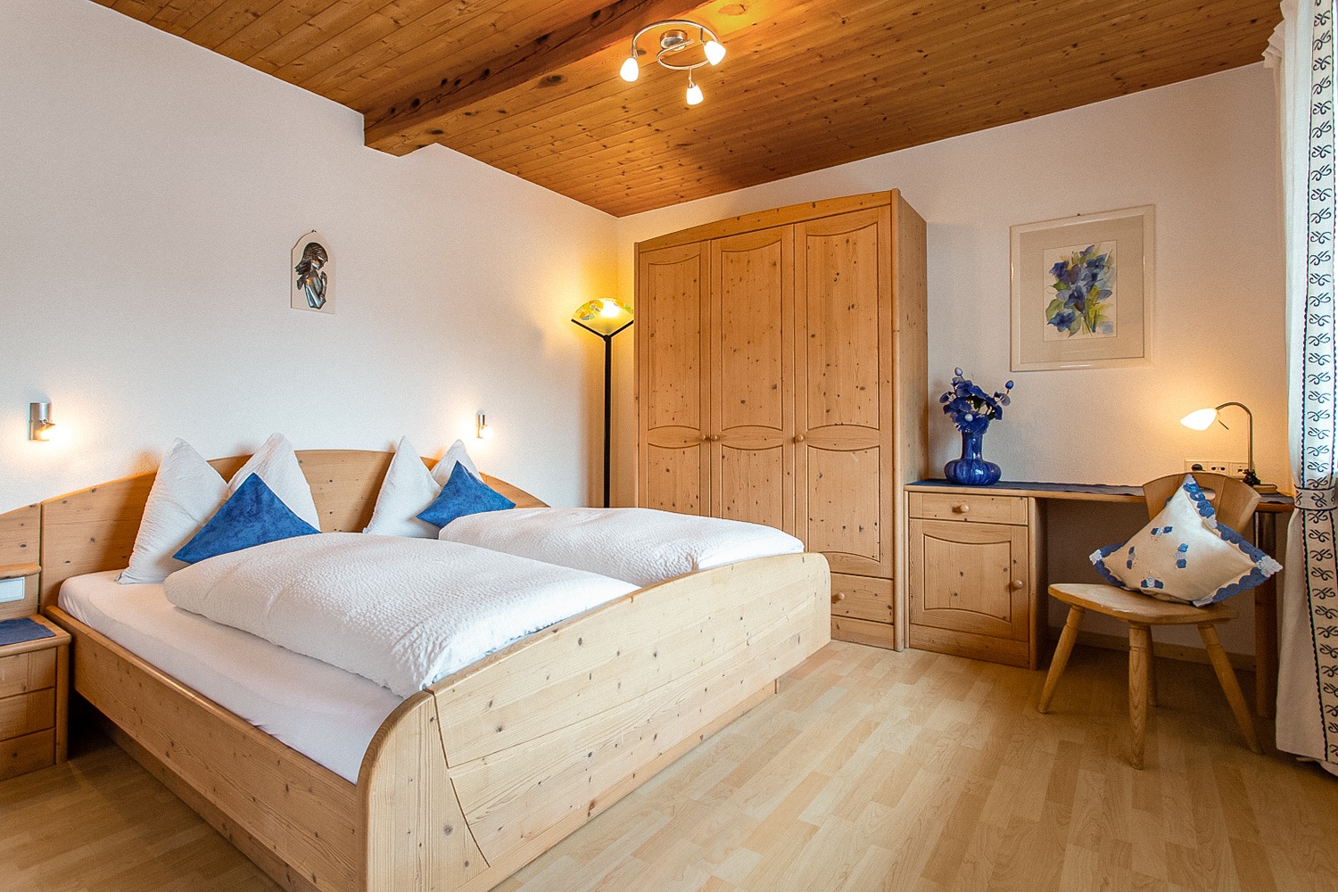 Helles Schlafzimmer mit Doppelbett, Schreibtisch und traumhaftem Panoramablick – perfekt zum Entspannen und Arbeiten.